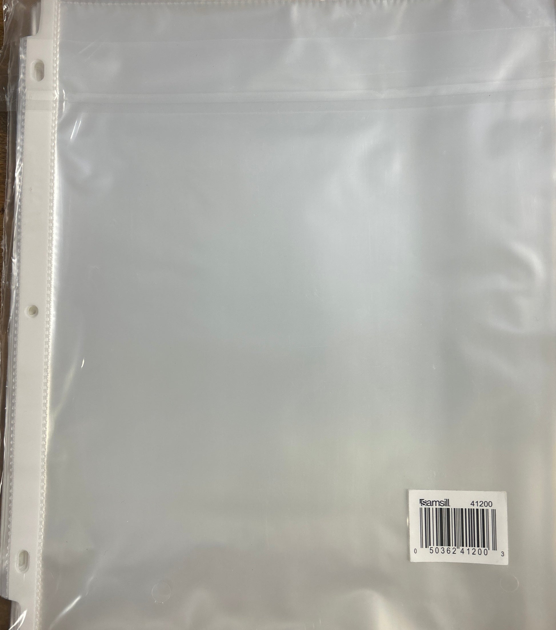 Clear plastic sheet with a barcode label on a wooden surface