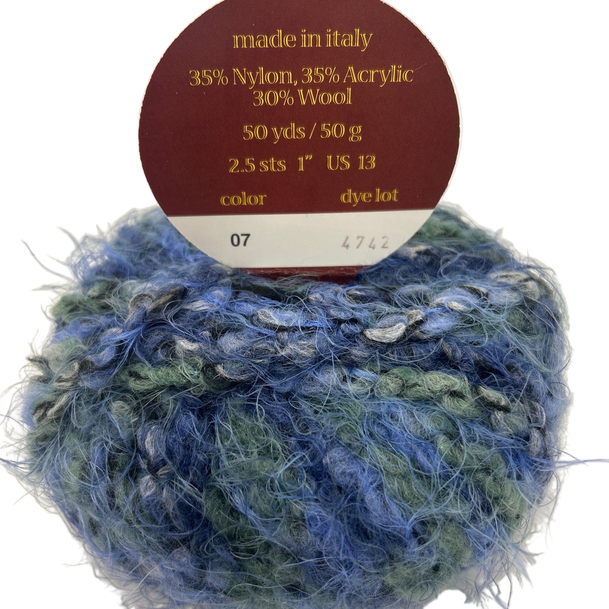 Blue and green yarn ball with a label indicating it is made in Italy and contains 35% nylon, 35% acrylic, and 30% wool.
