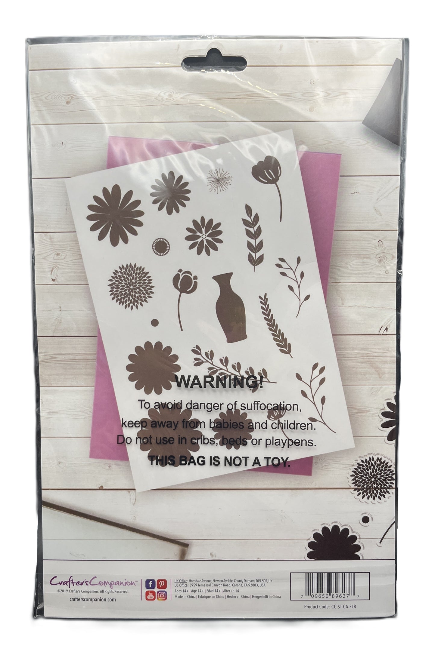 Floral design stencils in a packaging with warning label on a wooden surface
