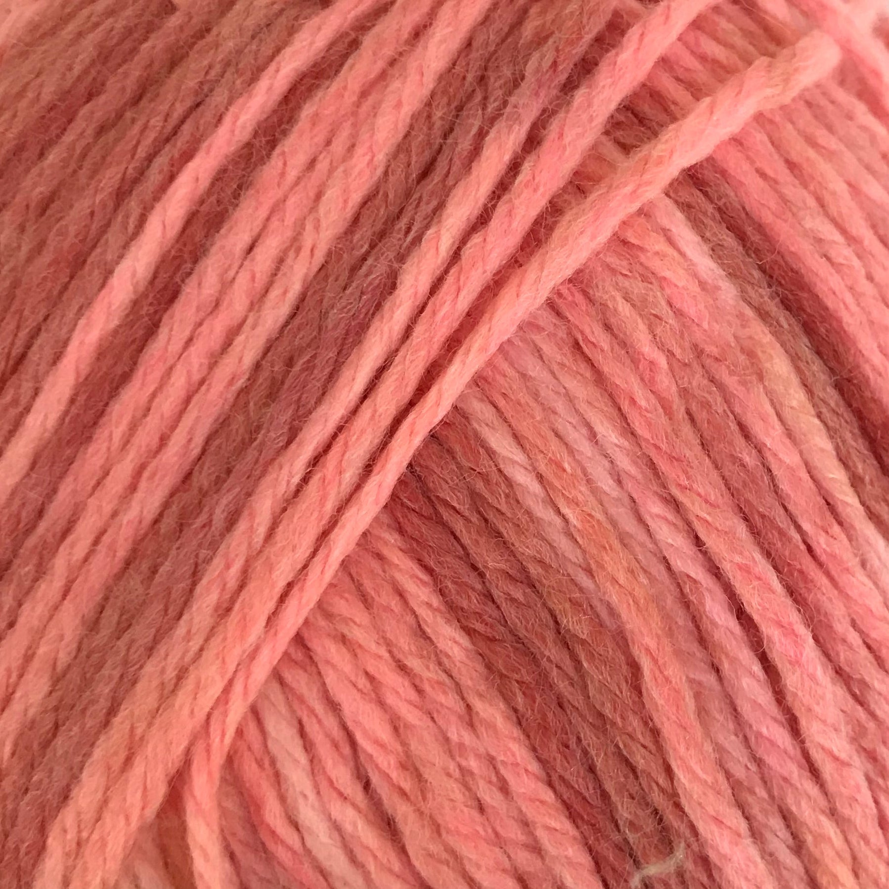 Ball of pink yarn with a label on a white background