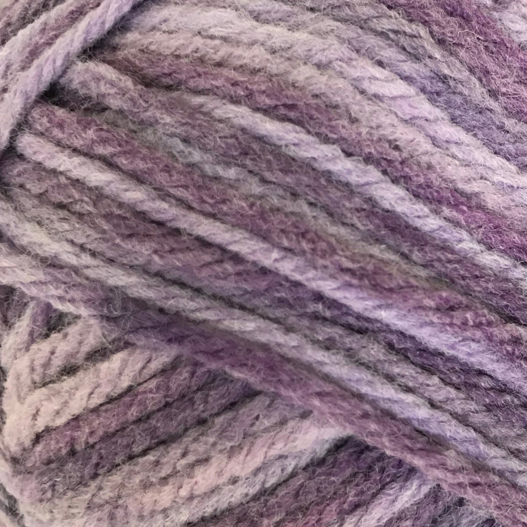 Ball of purple yarn with a label on a white background
