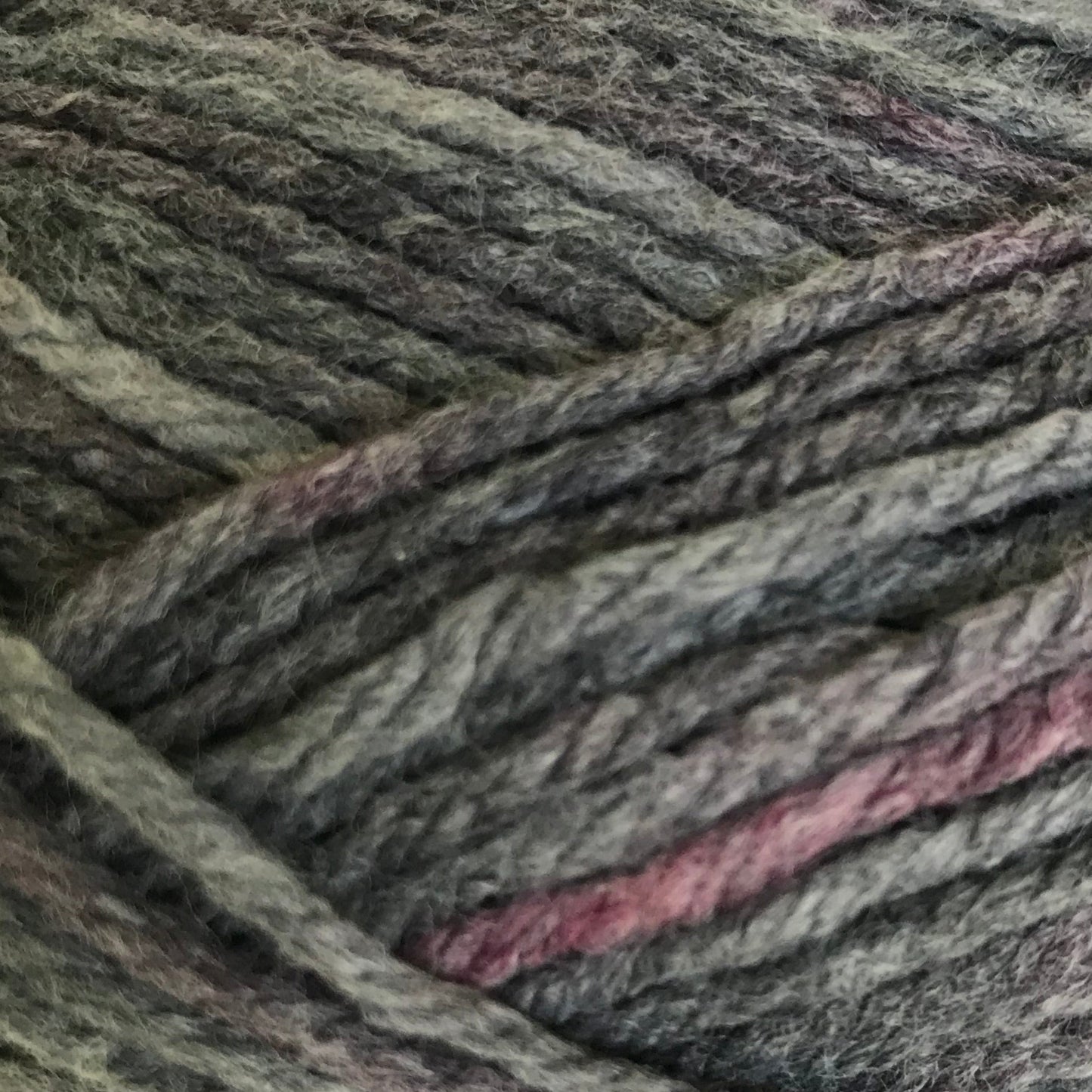 Ball of gray yarn with pinkish tones on a white background