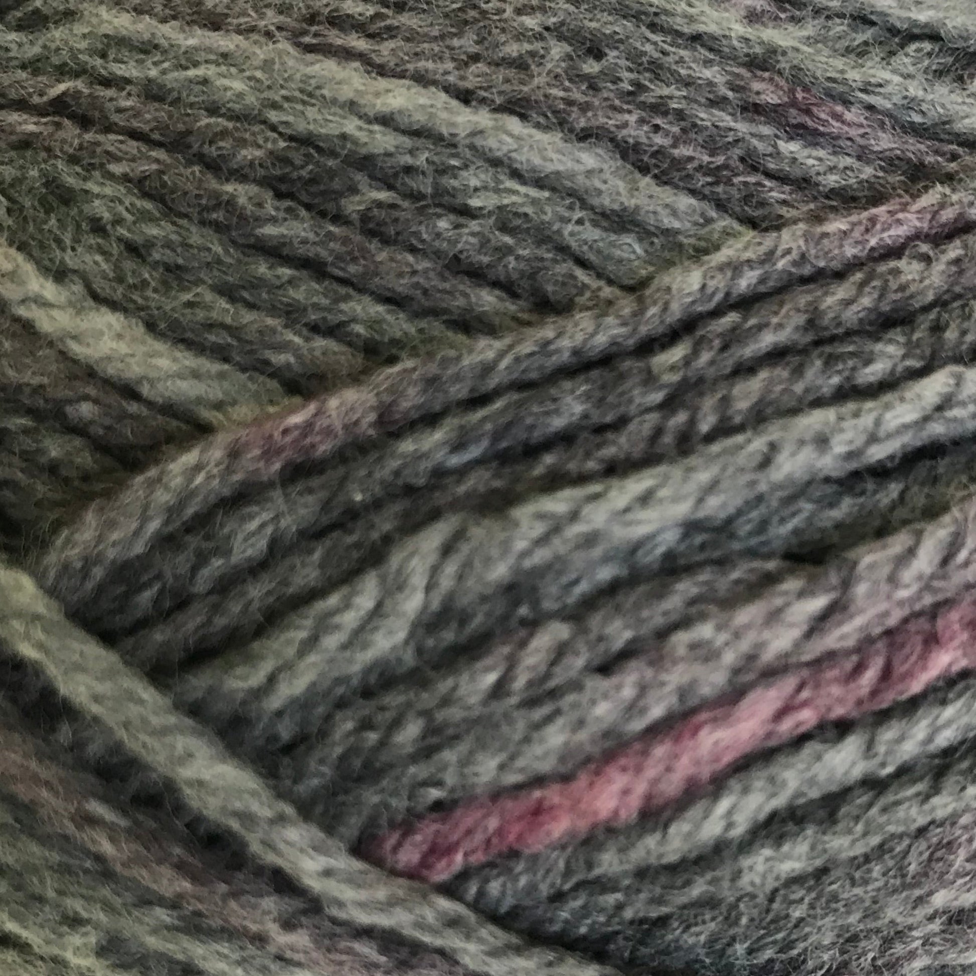 Ball of gray yarn with pinkish tones on a white background