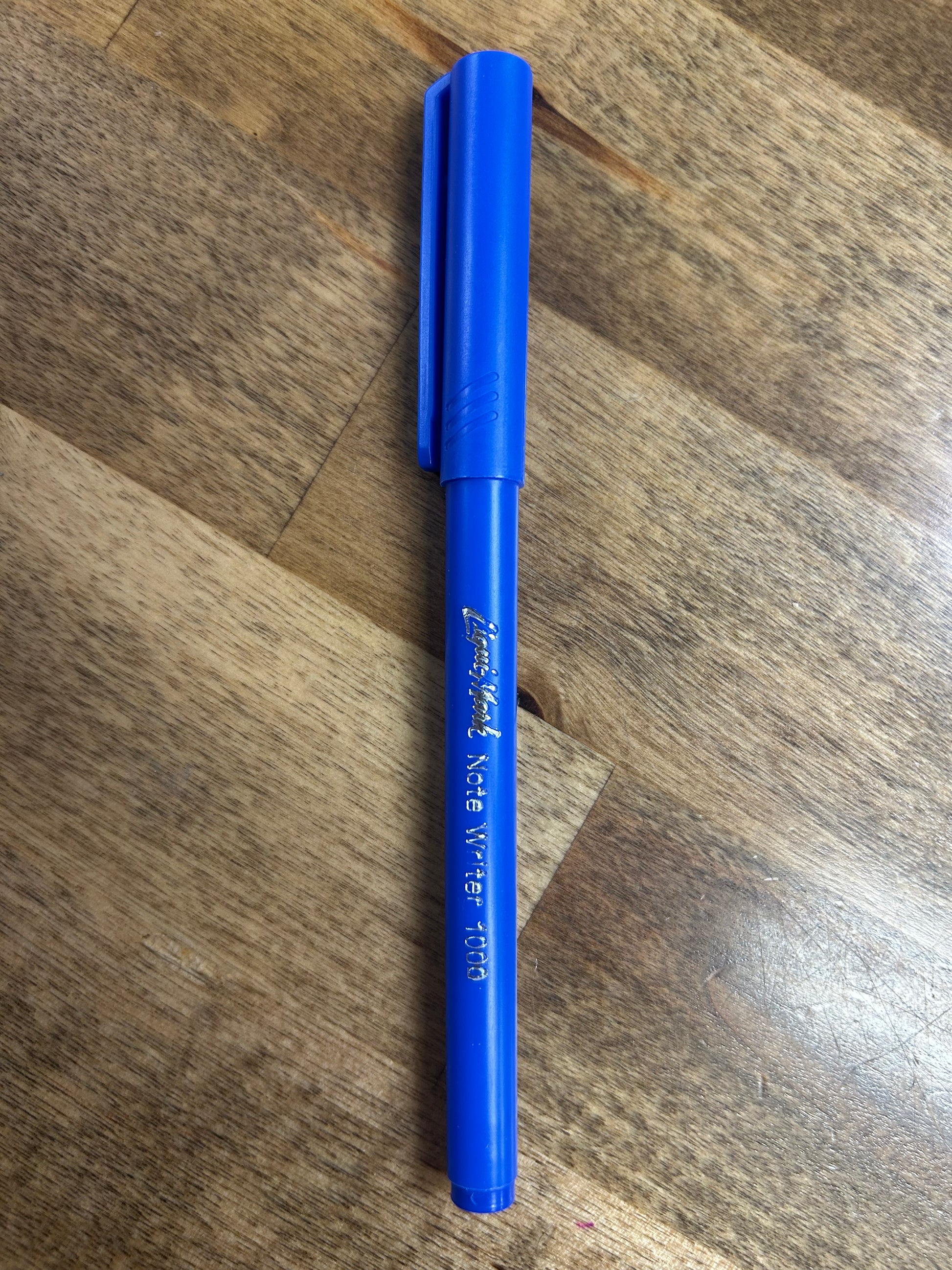 Blue pen on a wooden surface