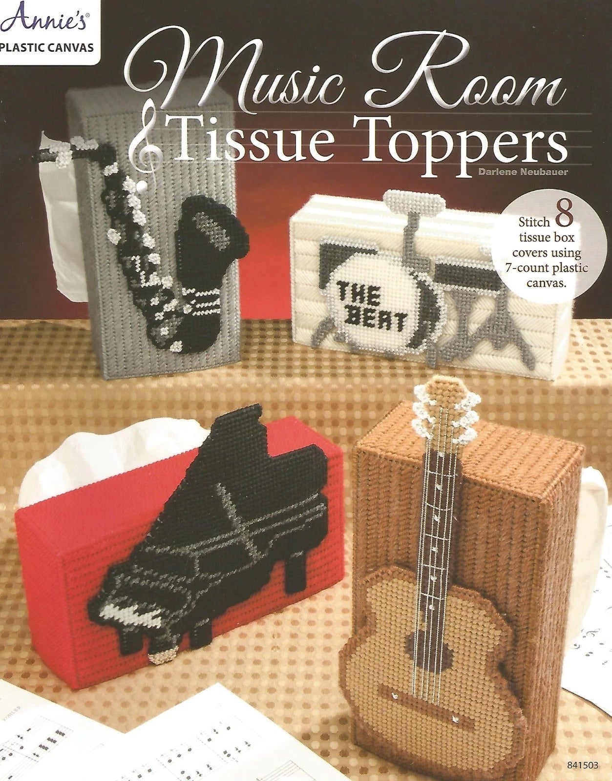 Music-themed tissue toppers with guitar, piano, and record player designs on a checkered tablecloth.