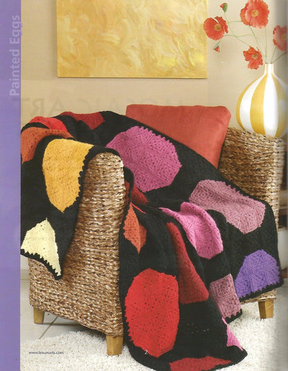 Colorful crocheted blanket draped over a chair in a living room setting.