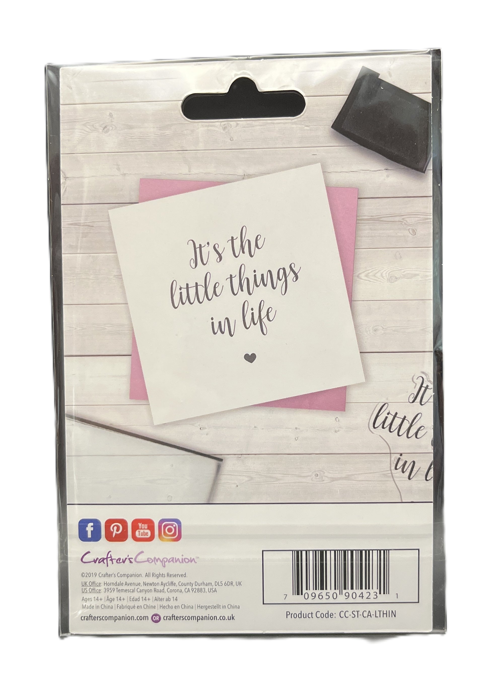 Packaged card with 'It's the little things in life' text on a wooden surface