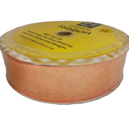 Spool of peach-colored ribbon with a yellow label on a white background