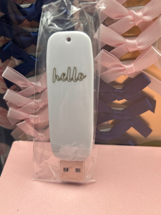USB drive with 'hello' tag on a pink background