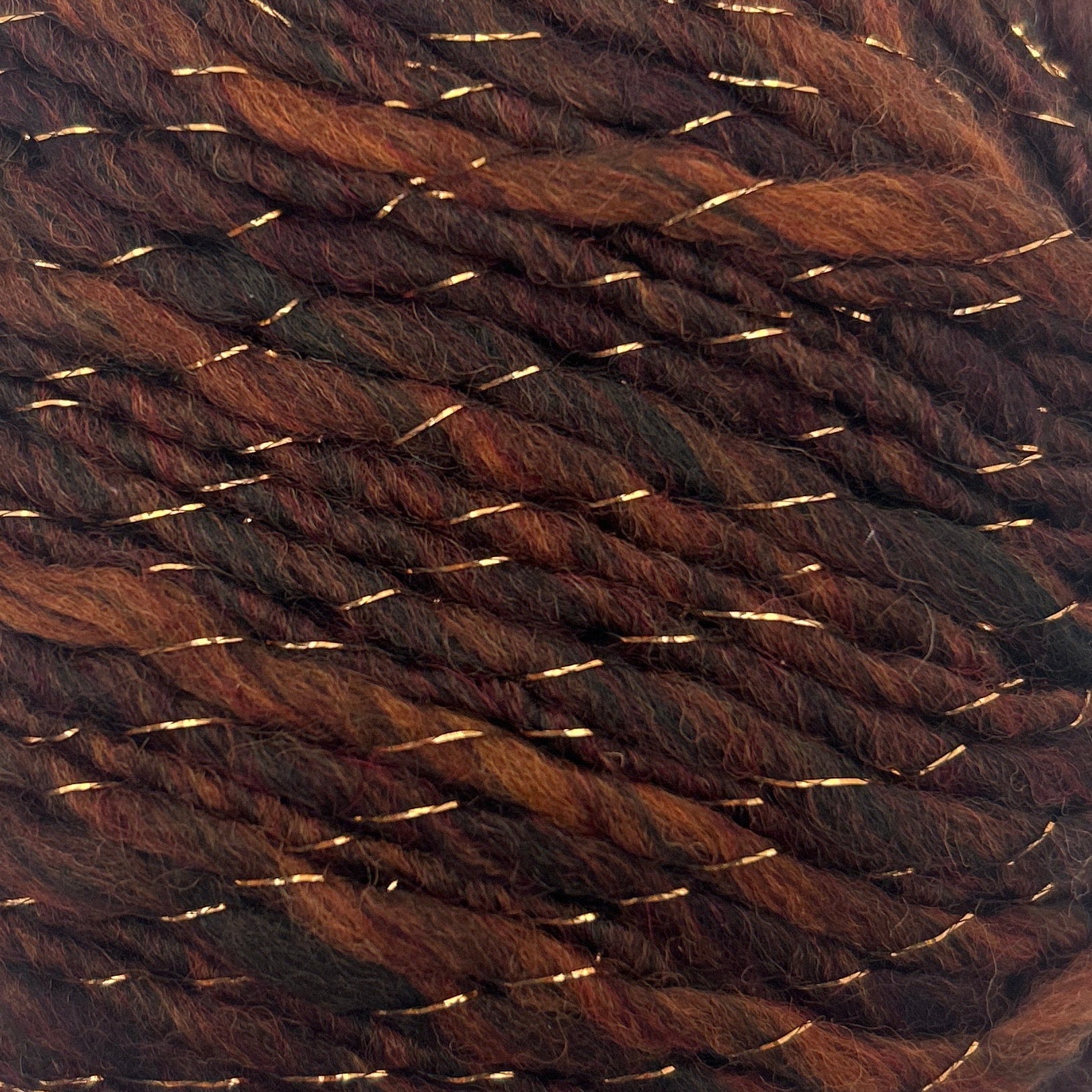 Brown yarn ball with gold threads on a white background