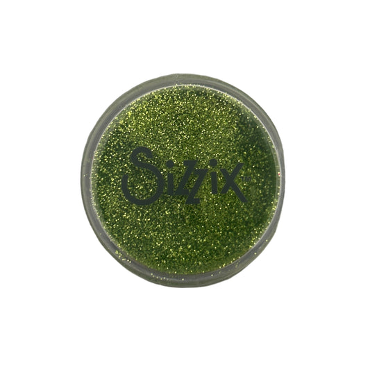 Green glittery powder in a Sizzix container on a white background