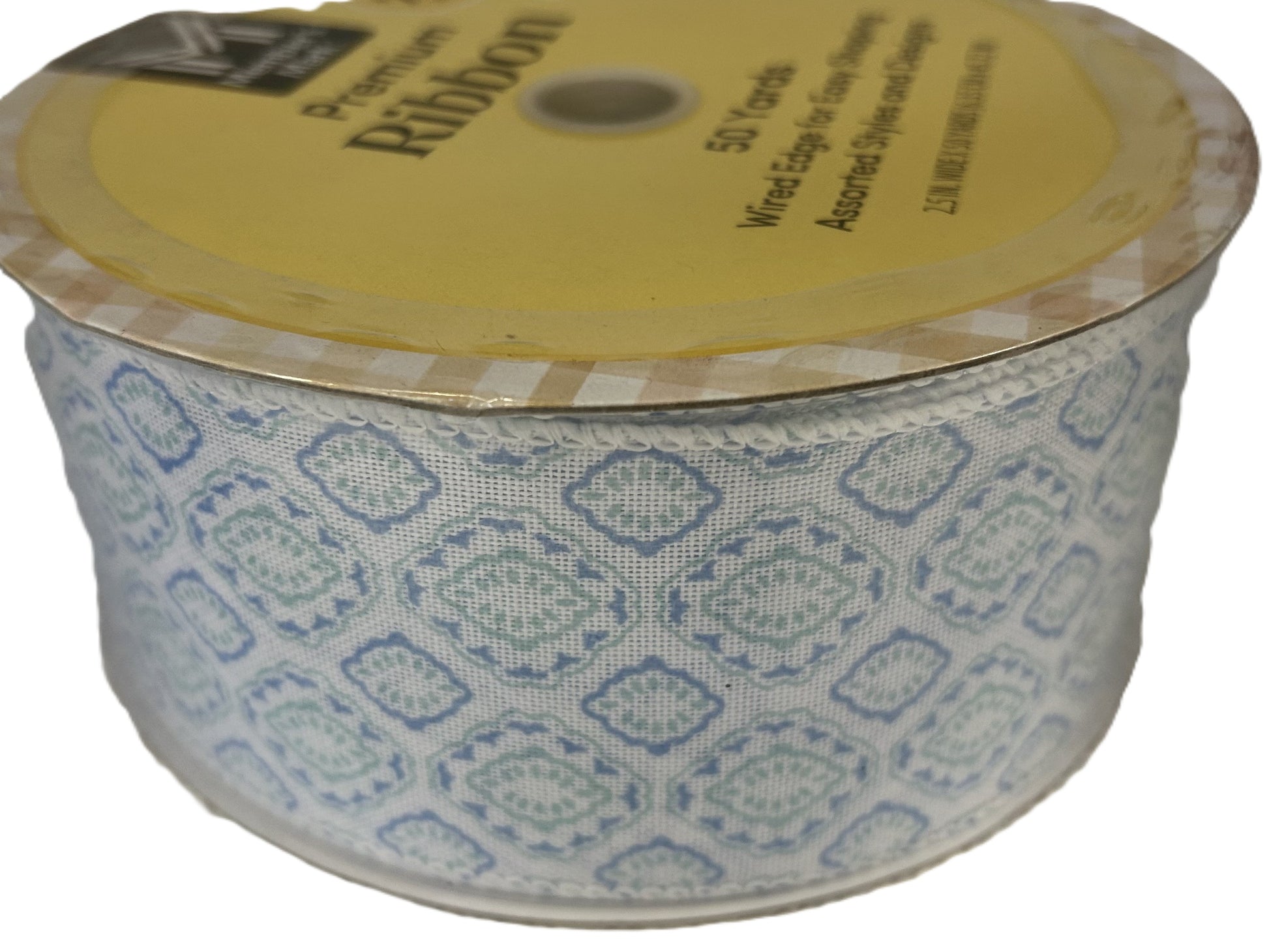 Spool of patterned ribbon with a yellow label on a white background