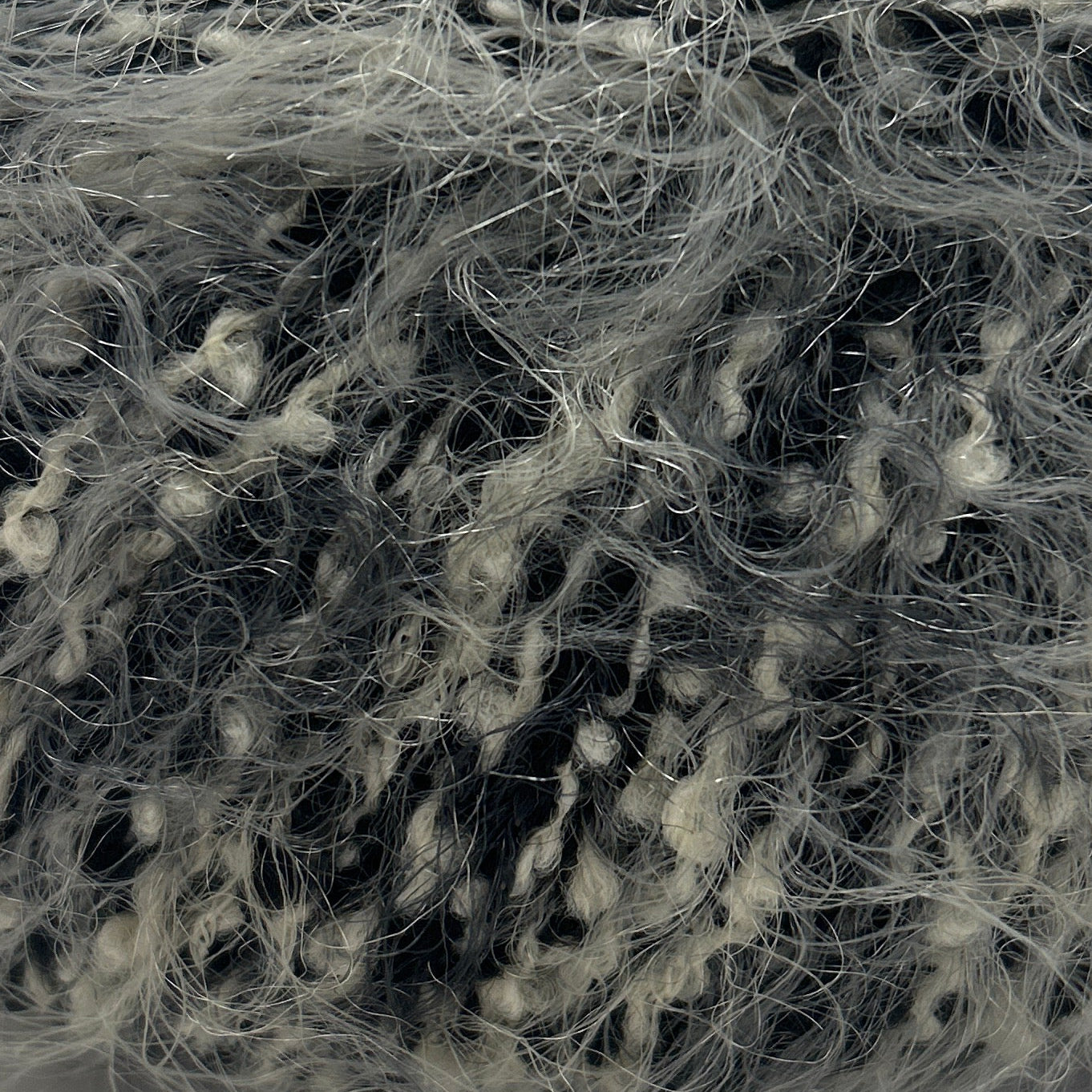 Ball of gray yarn with a label on a white background
