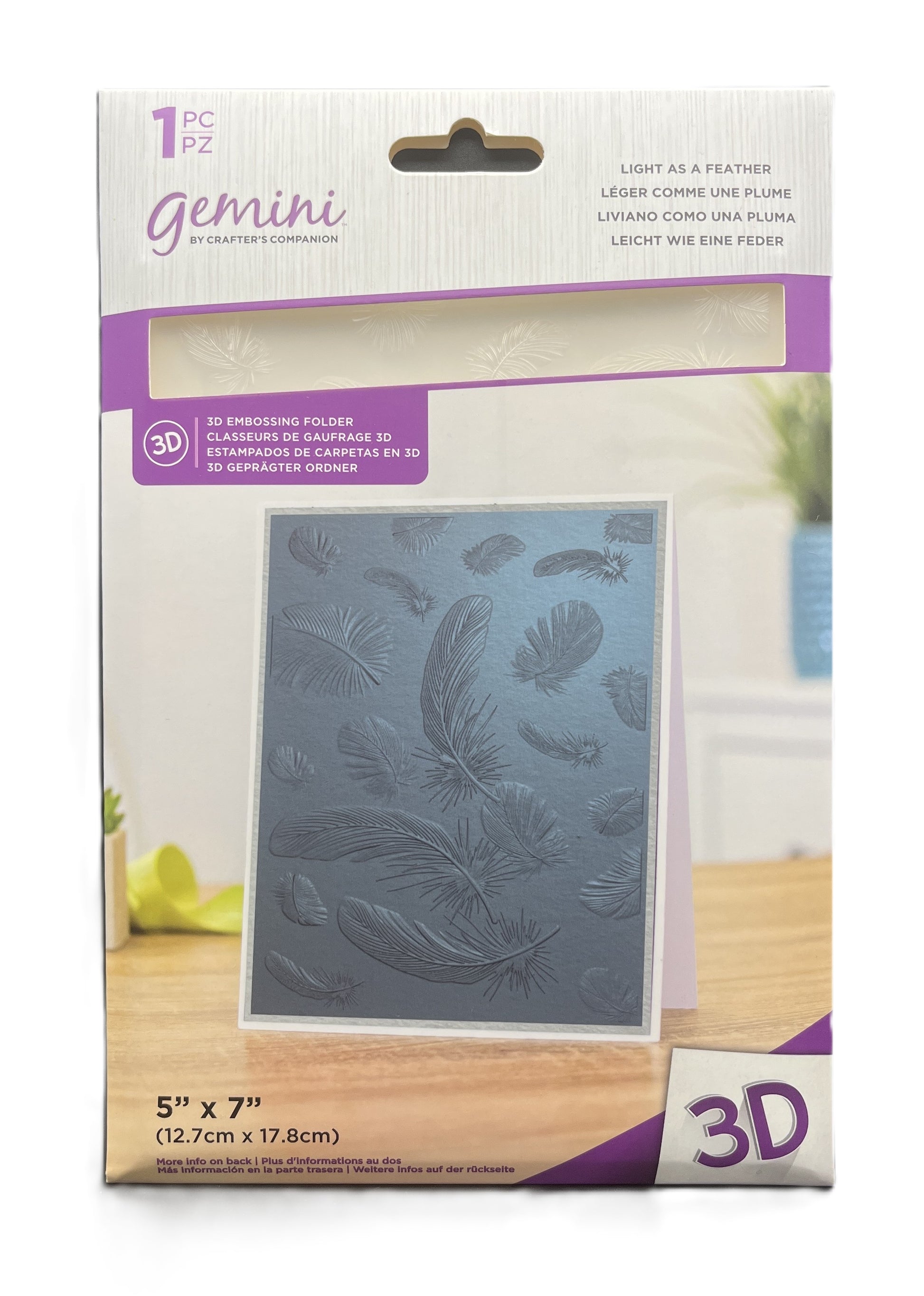 Packaged 3D embossing folder with feather design on a wooden surface