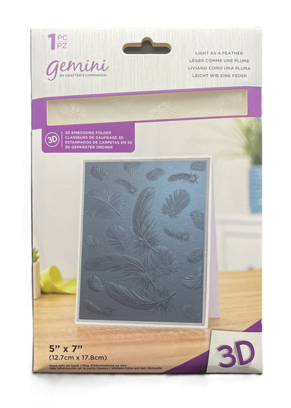 Packaged 3D embossing folder with feather design on a wooden surface