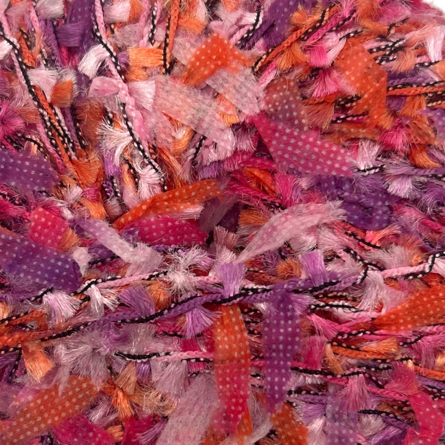 Close-up of colorful tinsel with pink, orange, and purple hues.