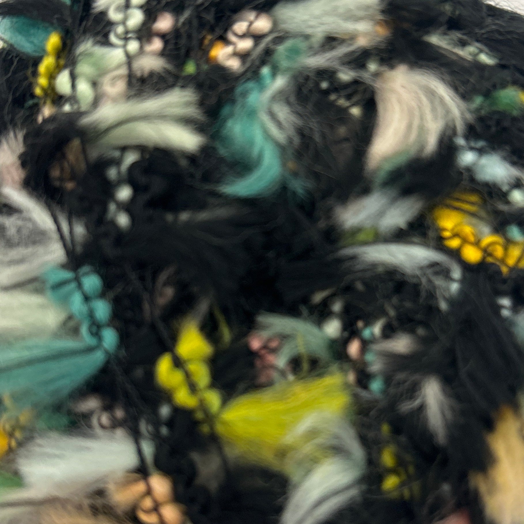 Colorful feathered object on a light gray background
