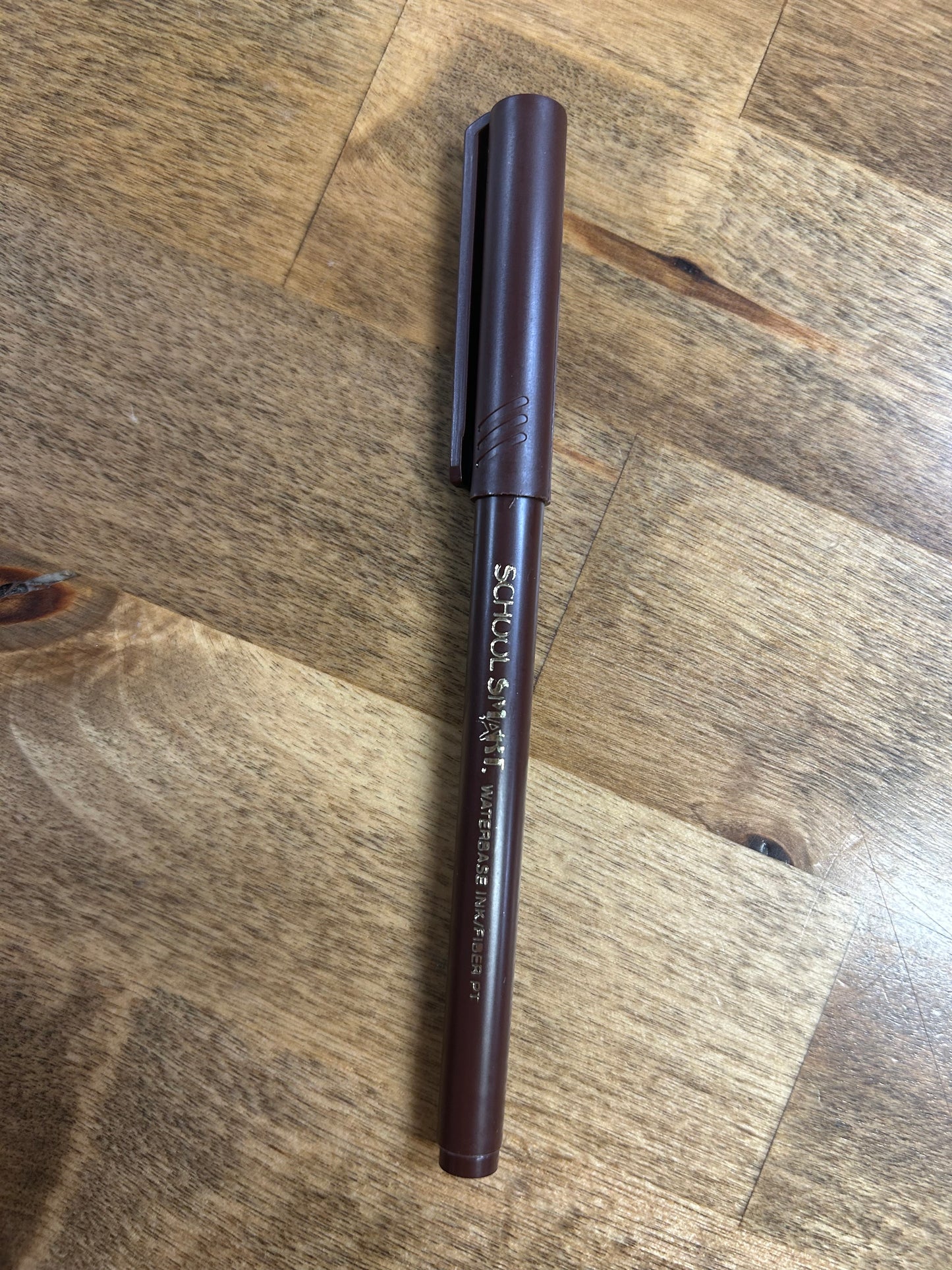 Brown pen on a wooden surface