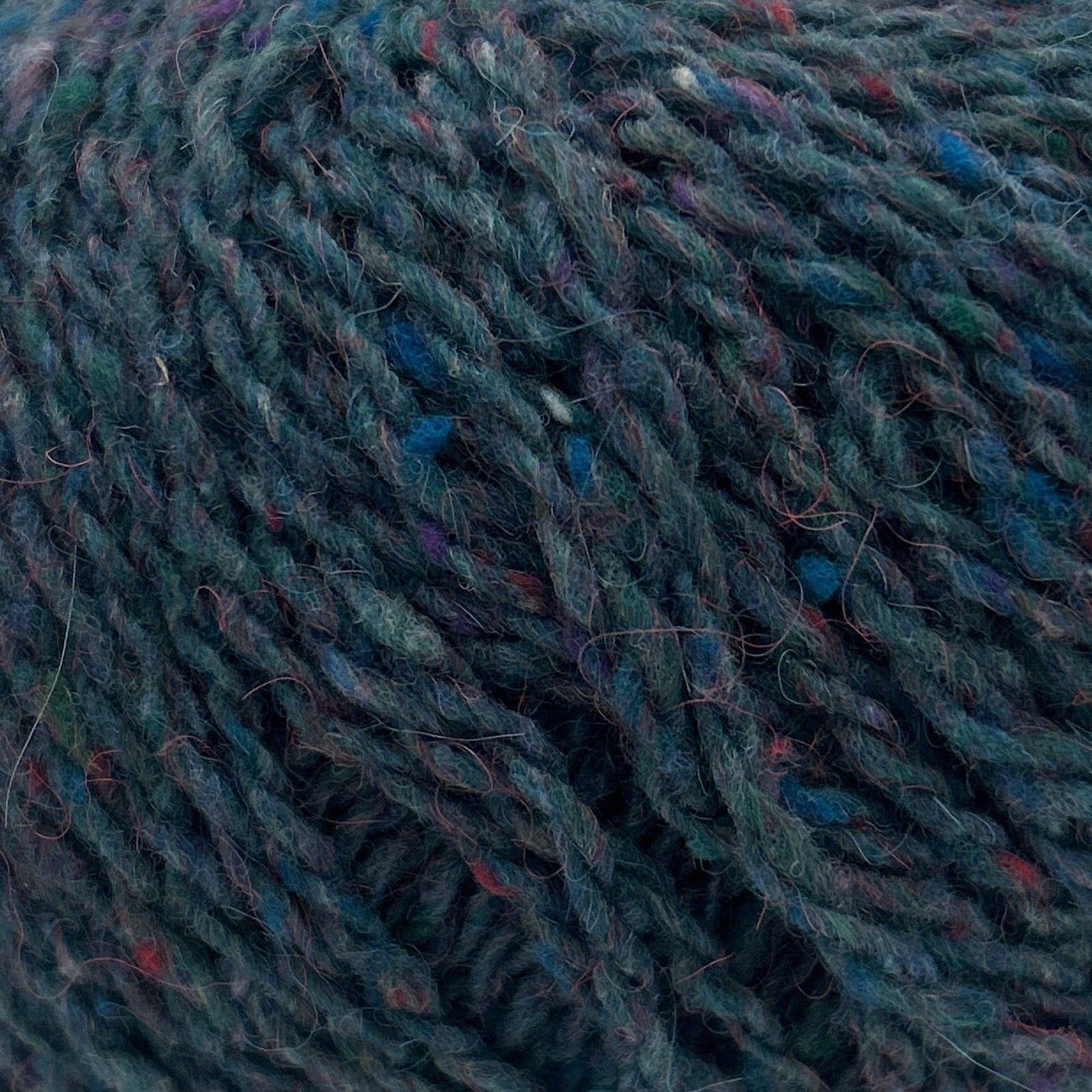 Blue skein of yarn with a label on a white background