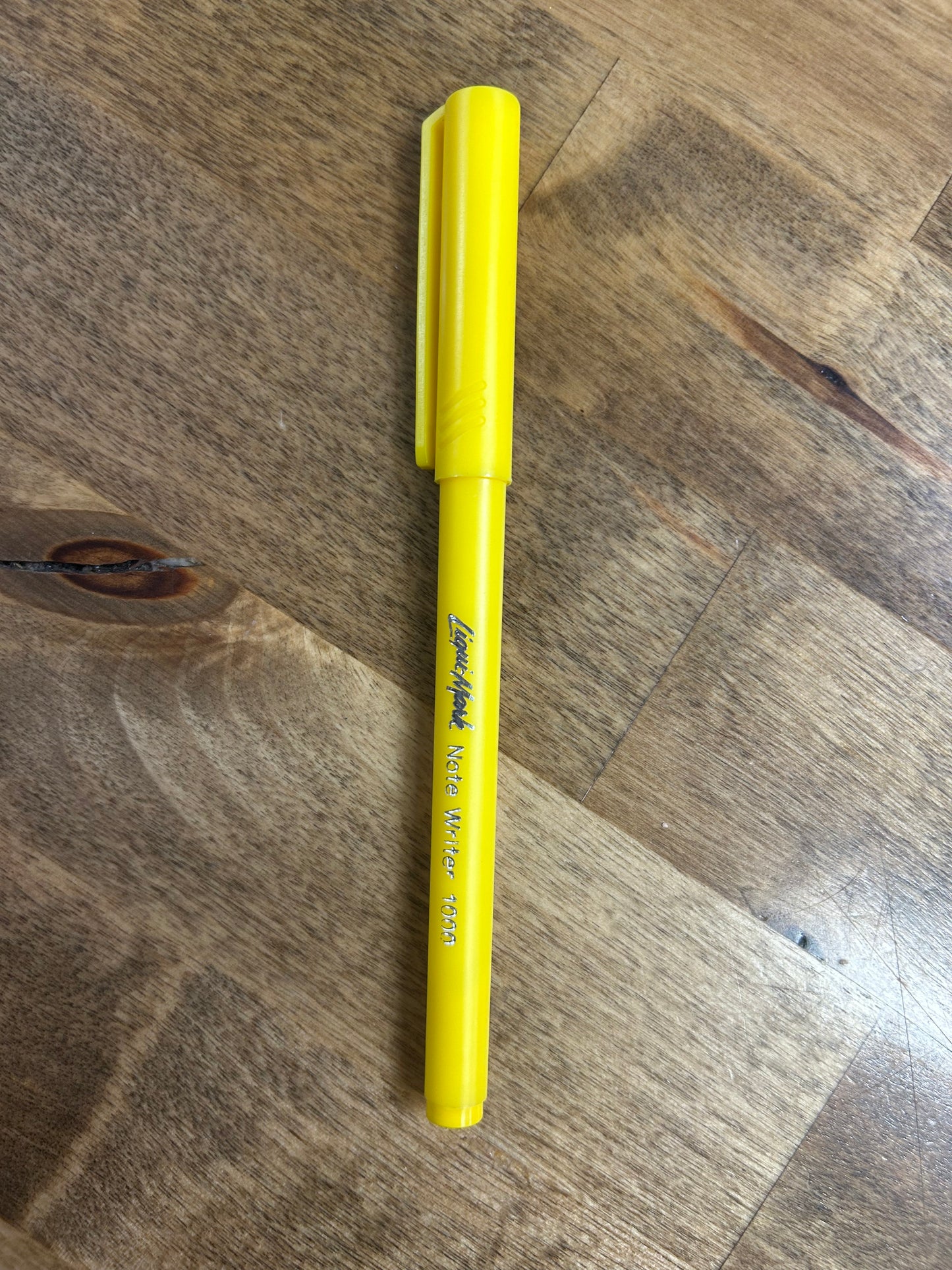 Yellow marker on a wooden surface