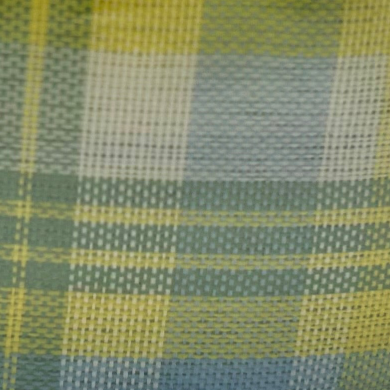 Roll of yellow and green plaid ribbon on a white background