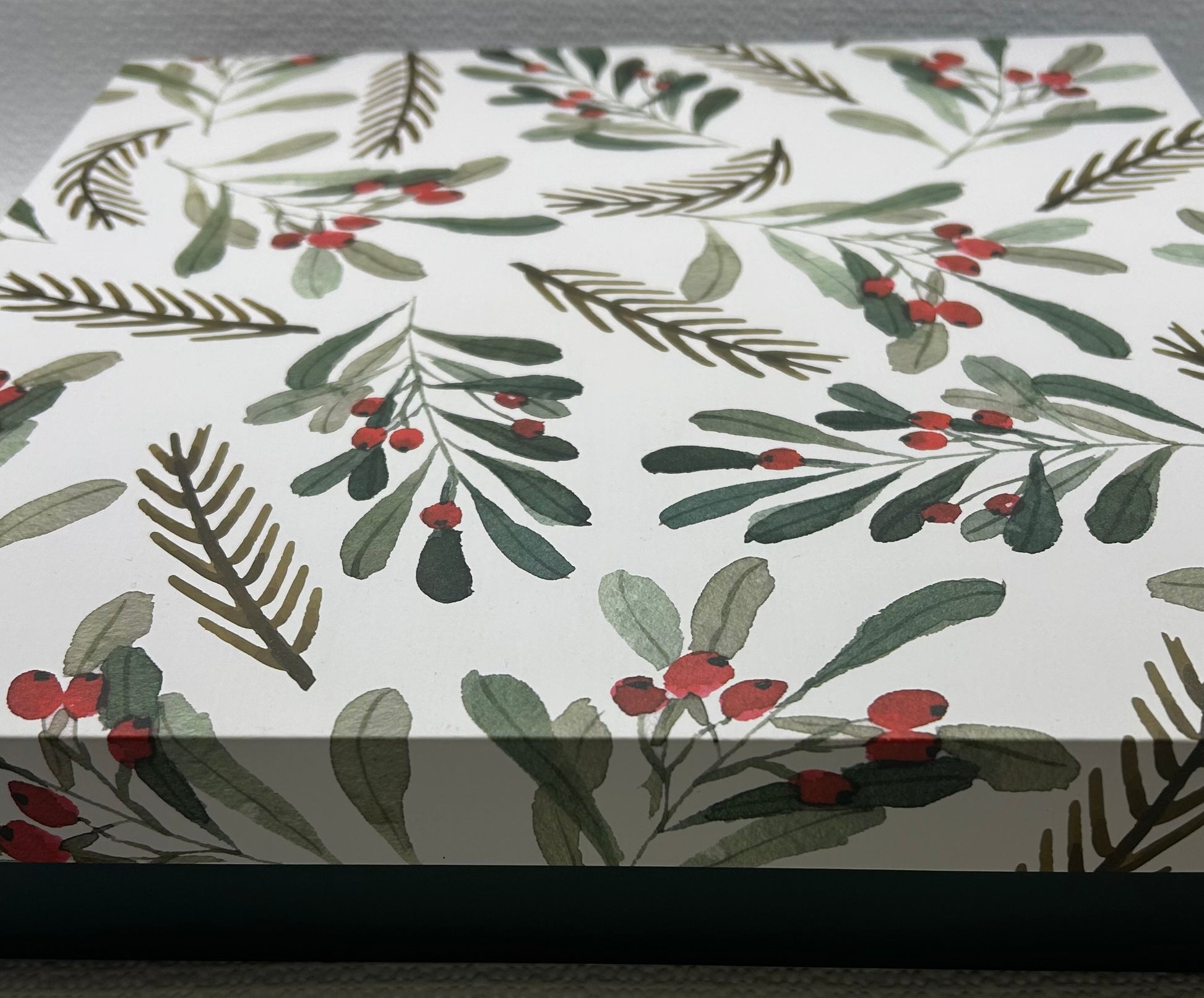 Wrinkled paper with holly leaf and berry pattern on a white background