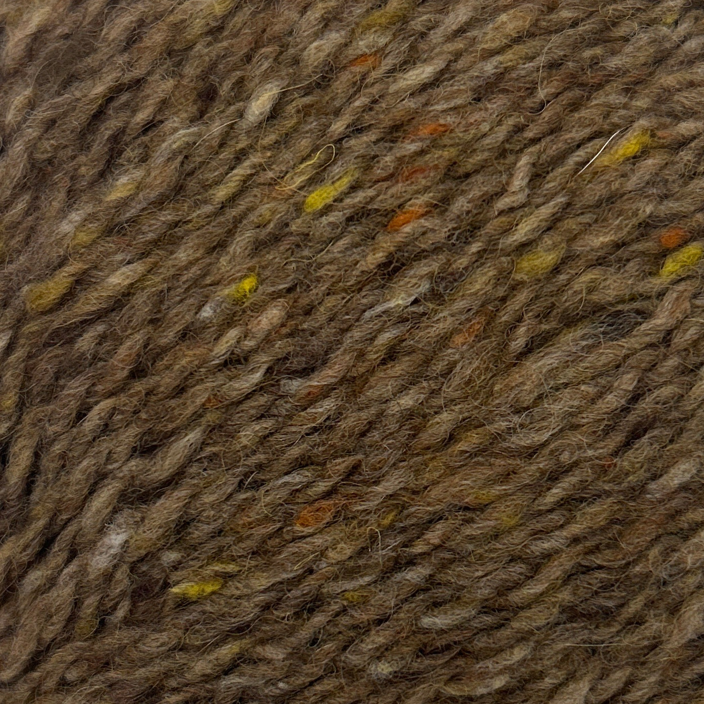 Close-up of brown fabric with small colorful specks