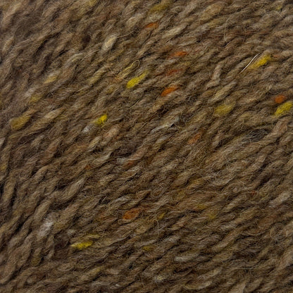 Close-up of brown fabric with small colorful specks