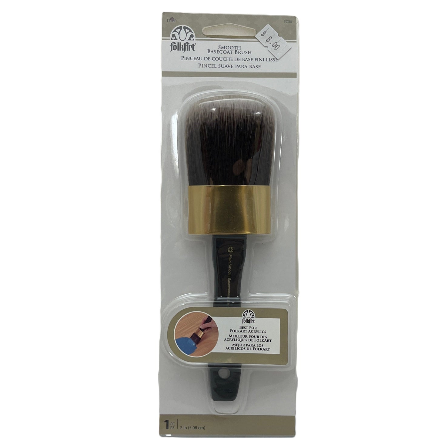 Makeup brush with gold ferrule and black bristles in packaging on a white background