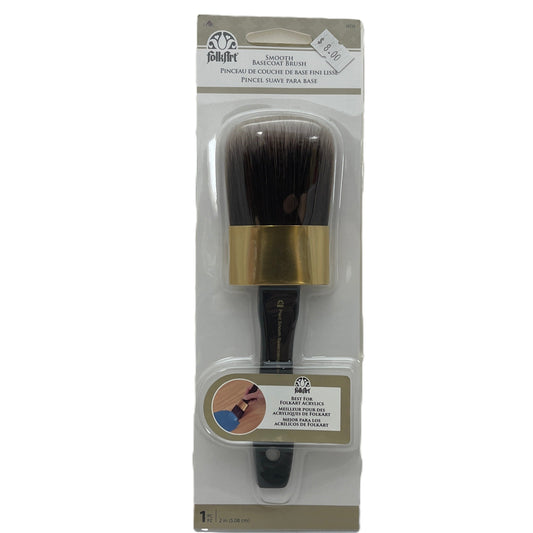 Makeup brush with gold ferrule and black bristles in packaging on a white background