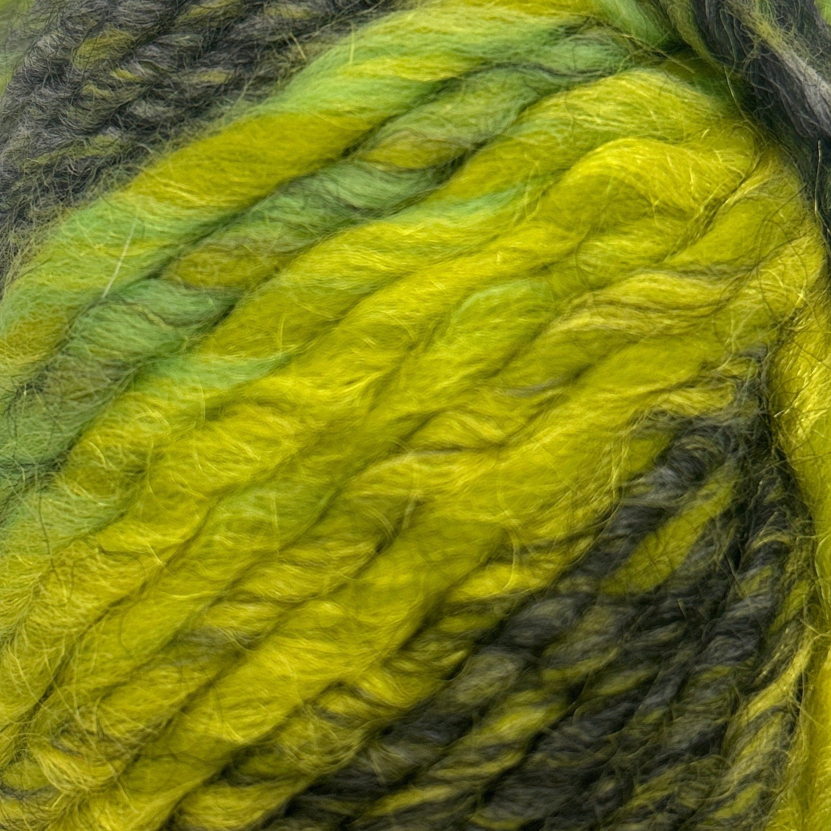 Ball of green and black yarn on a white background