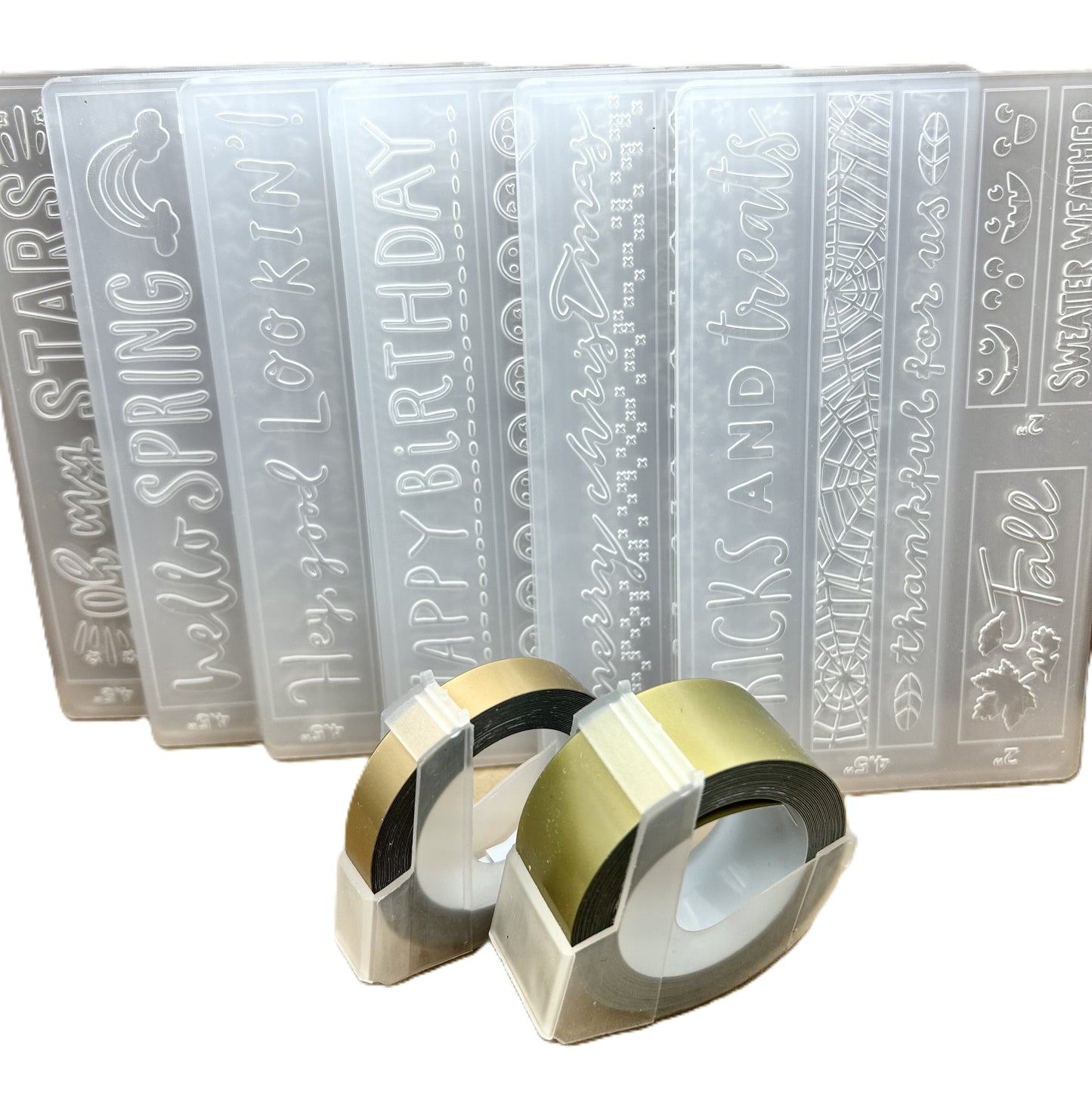 Set of embossing folders with various designs and text, accompanied by two embossing rolls.