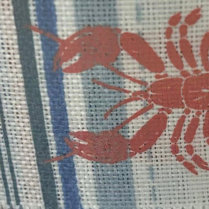 Close-up of a fabric with red lobster pattern on a striped background