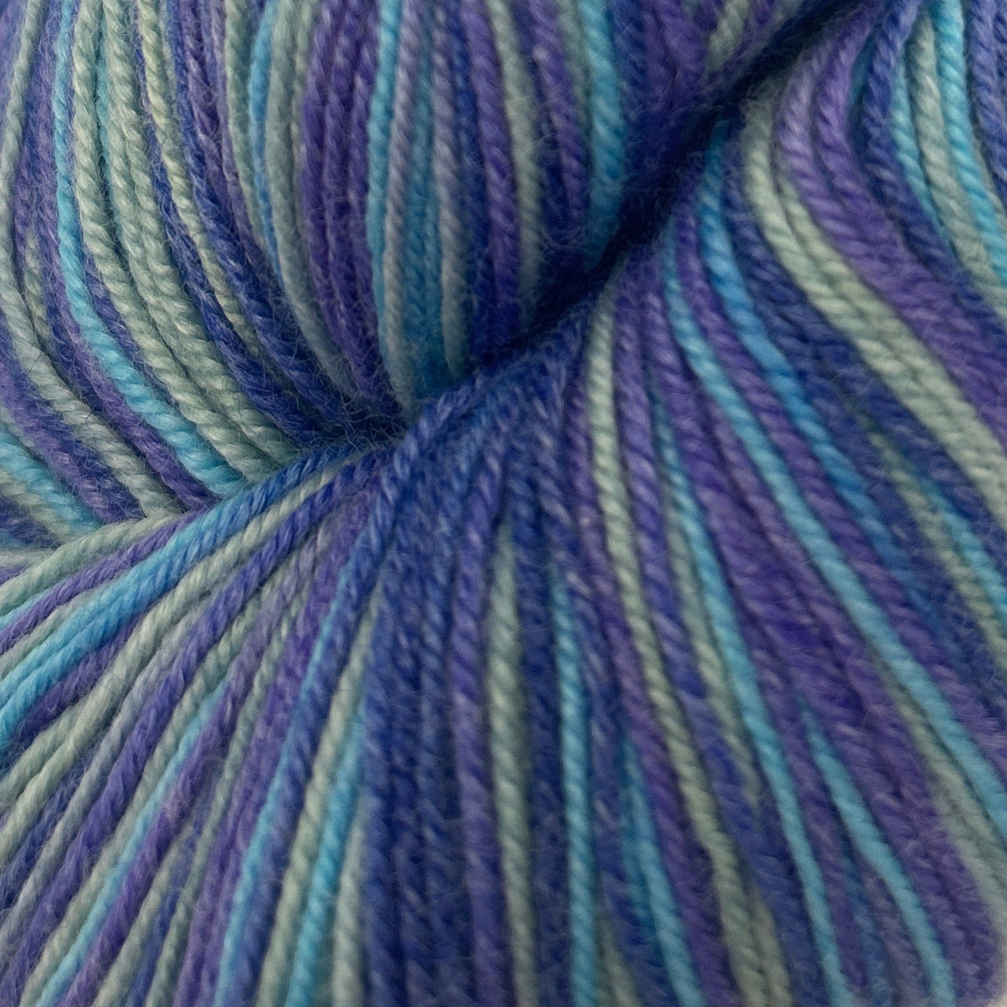 Blue and green striped yarn skein on a white background