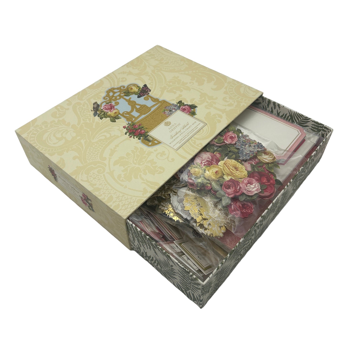 Decorative box with floral design and stationery items on a white background