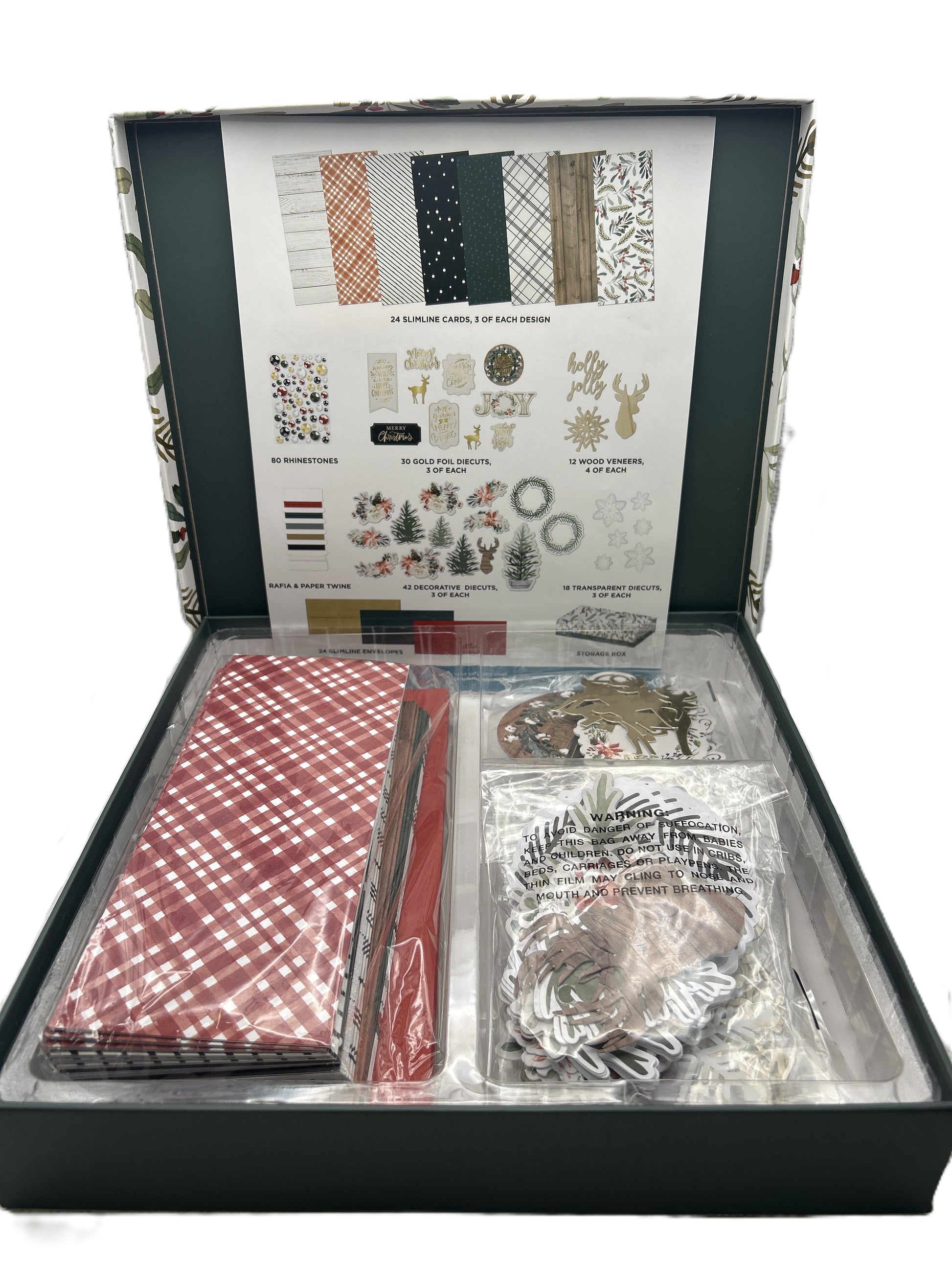 Open craft kit with various items including paper and embellishments on a white background