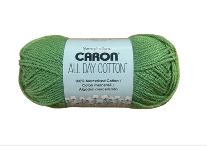 Green skein of Caron All Day Cotton yarn on a wooden surface
