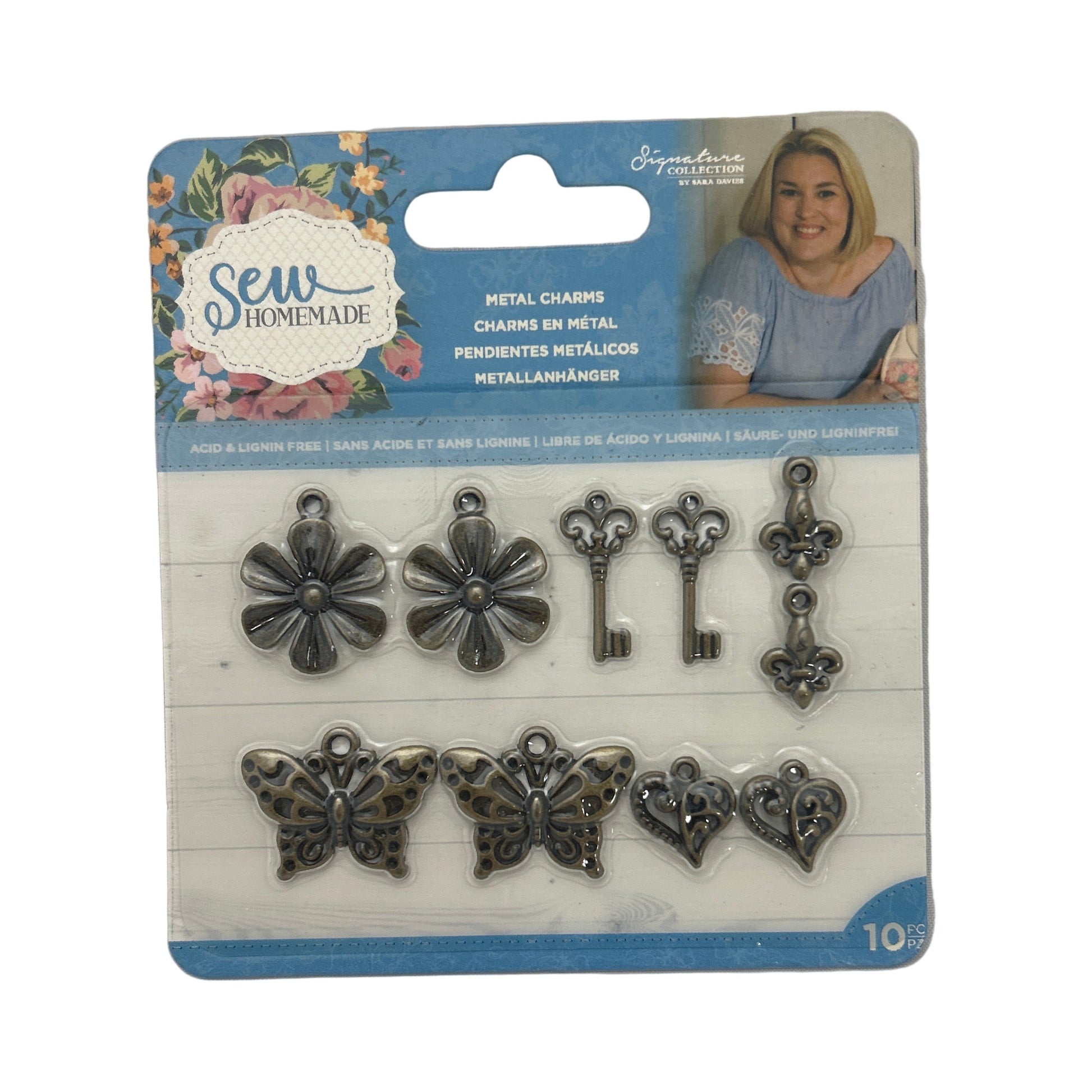 Packaged metal charms including flowers, keys, and butterflies on a white background.