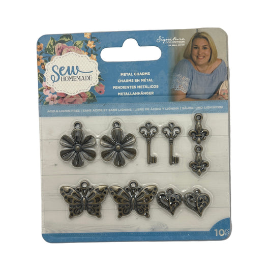 Packaged metal charms including flowers, keys, and butterflies on a white background.