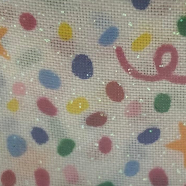 Decorative fabric with colorful polka dots and ribbons on a beige background