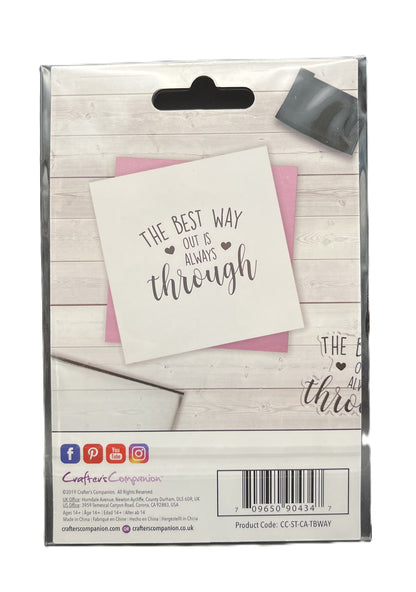 Packaged product with a card and pink envelope on a wooden surface, featuring text 'The best way out is always through'.