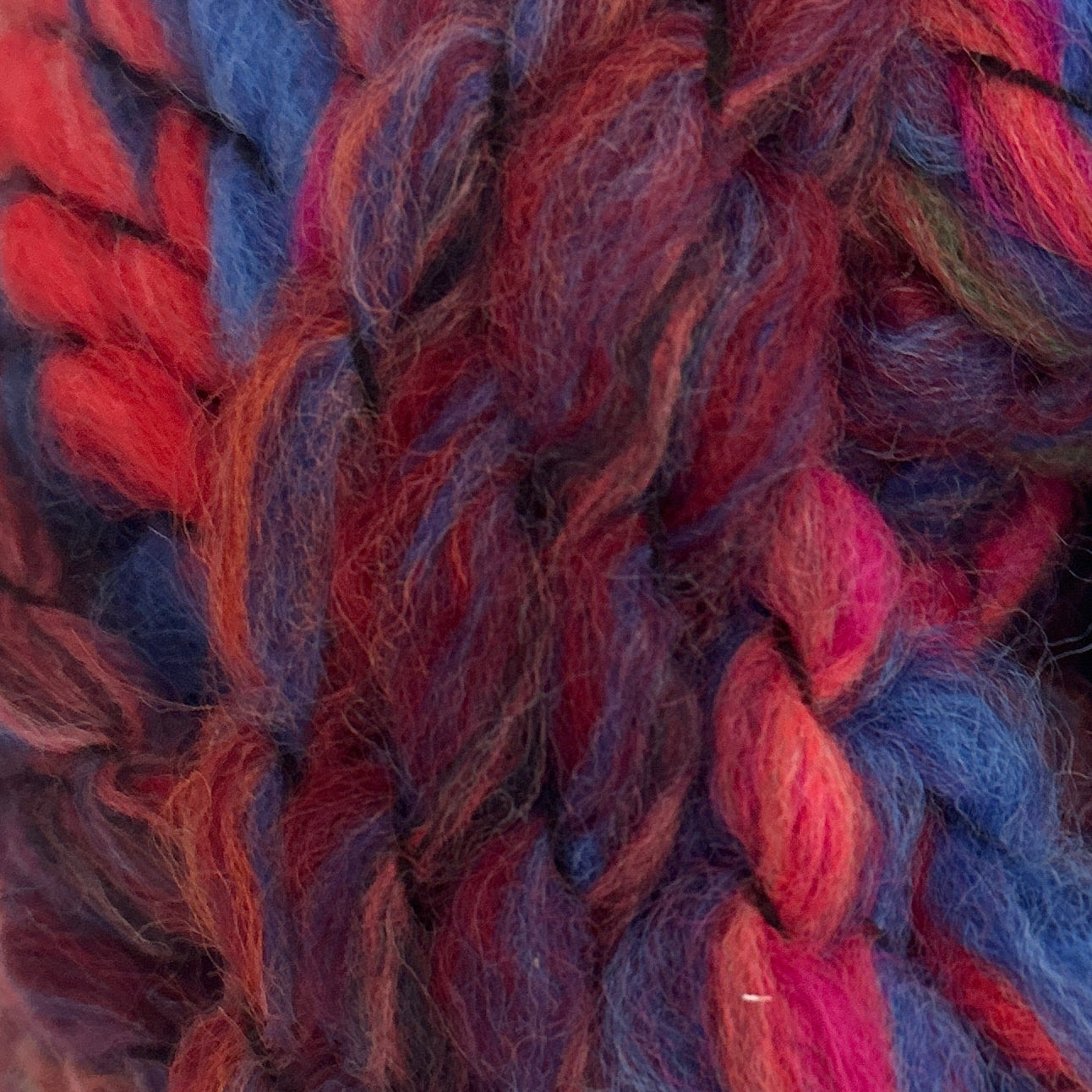 Close-up of multicolored yarn with red, blue, and pink hues.