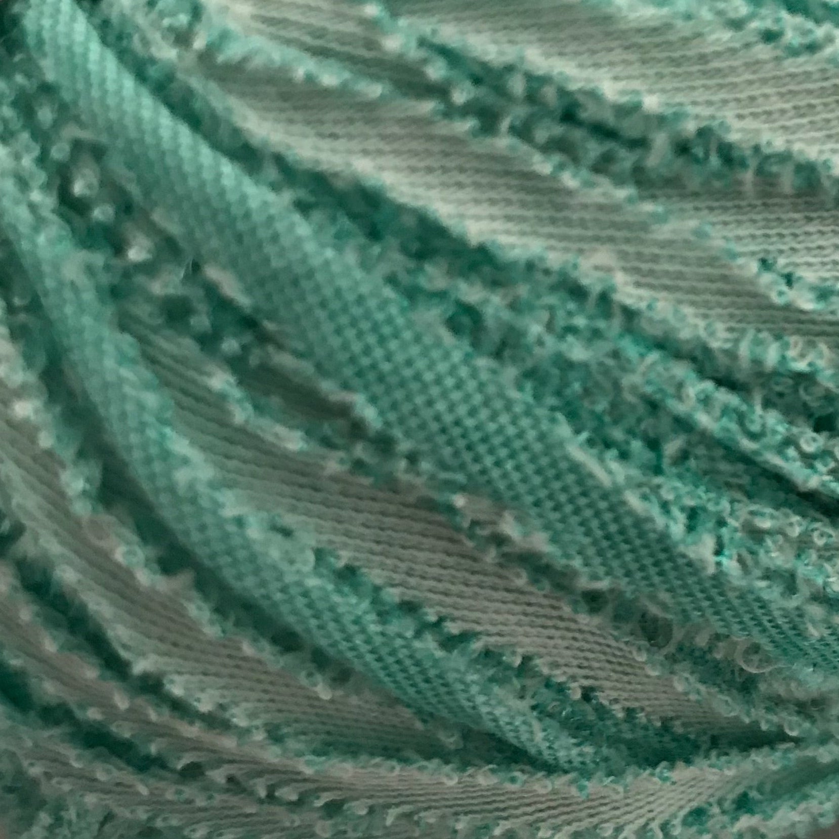 Turquoise scrunchie on a light gray background