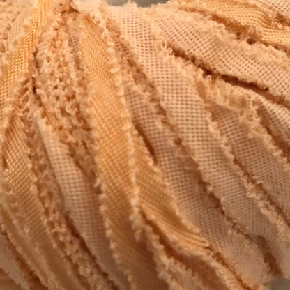 Ball of beige yarn with a label on a light background