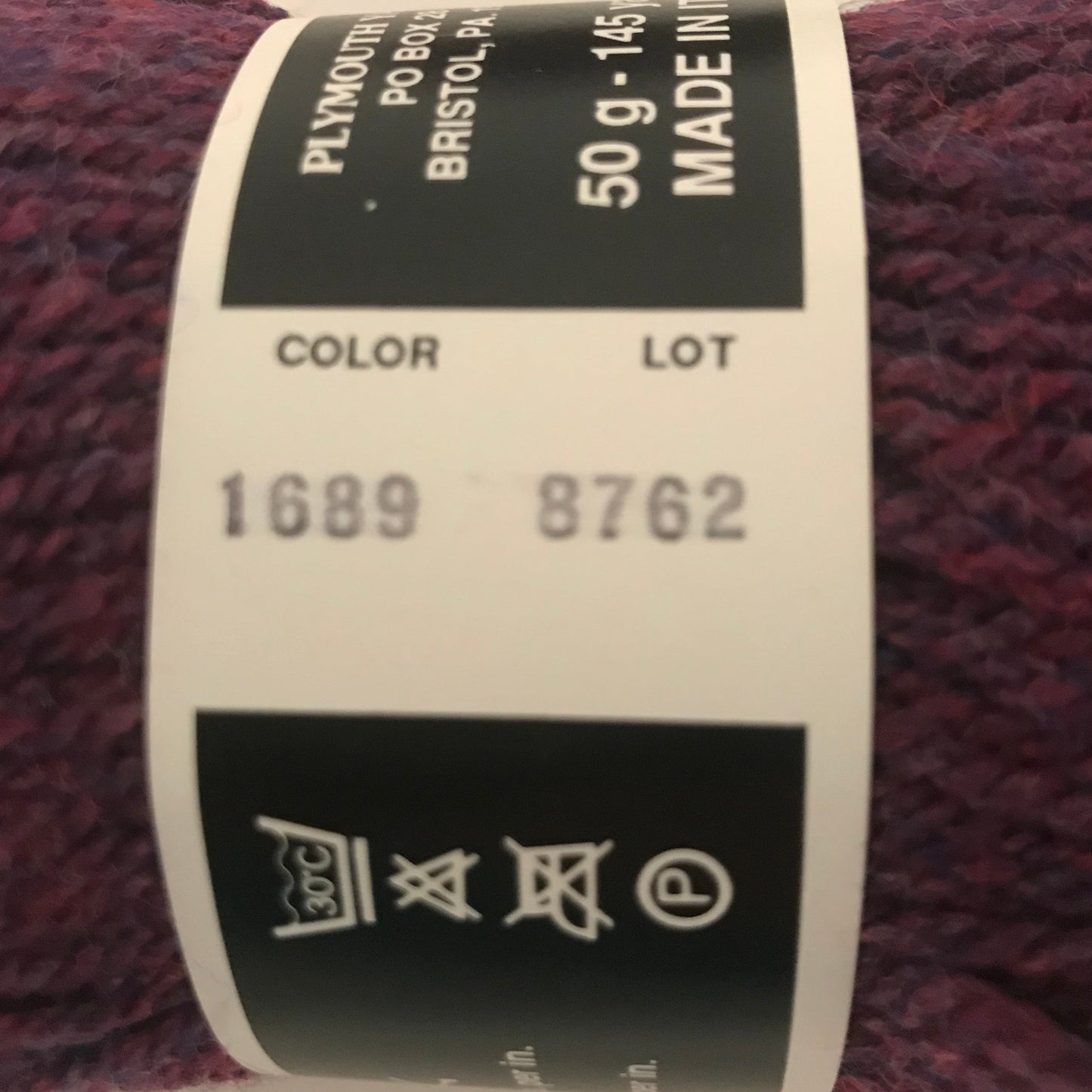 Close-up of a skein of yarn with a label on a beige background