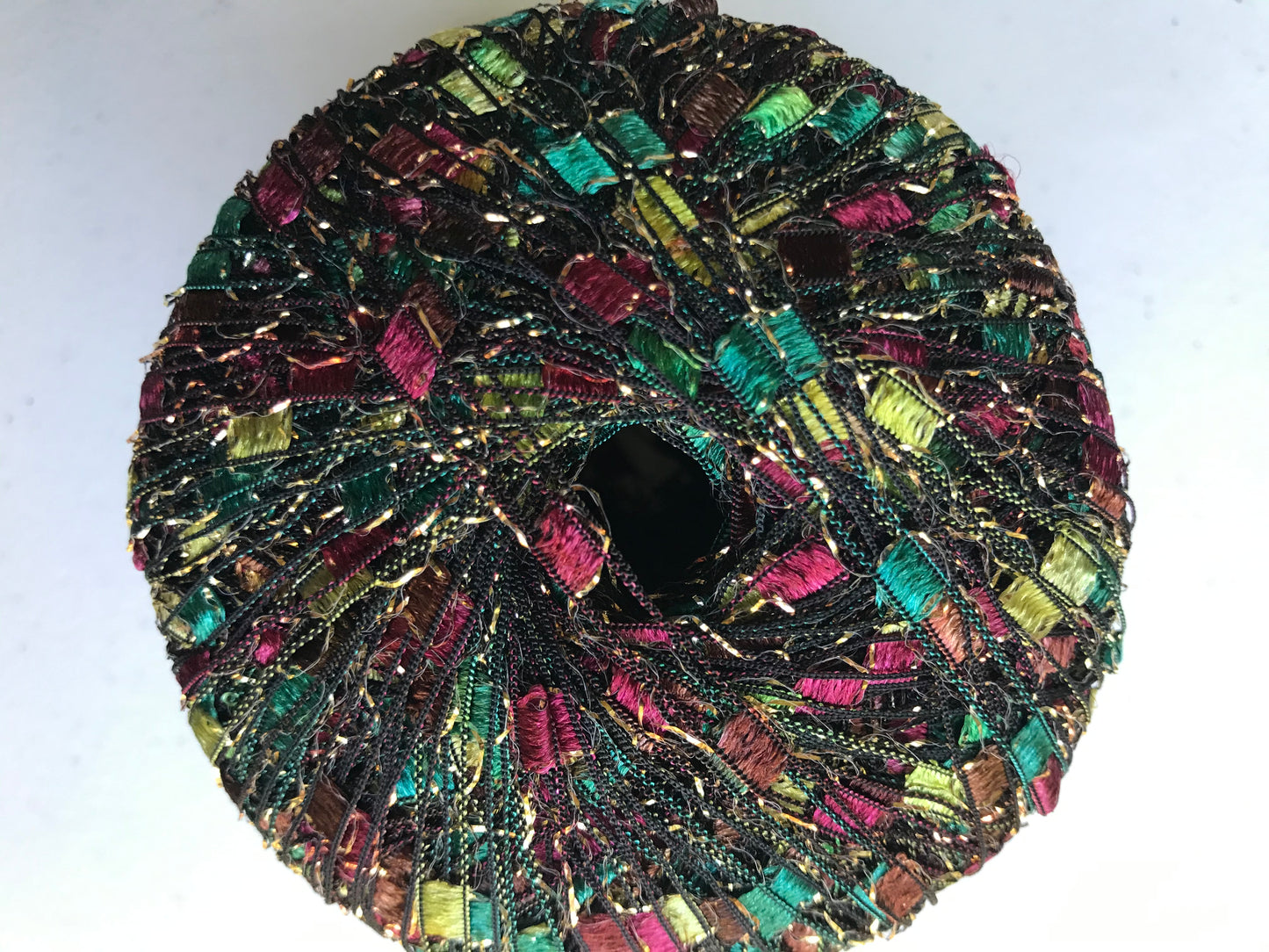 Multicolored beaded donut-shaped object on a white background