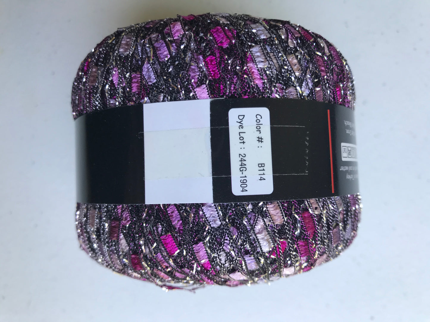 Multicolored yarn ball with a label on a white background
