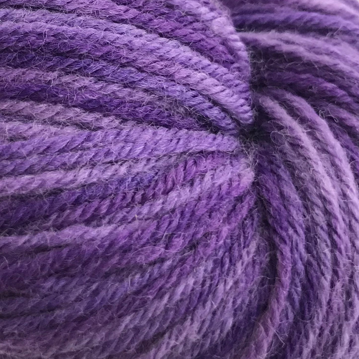 Purple skein of yarn on a white background