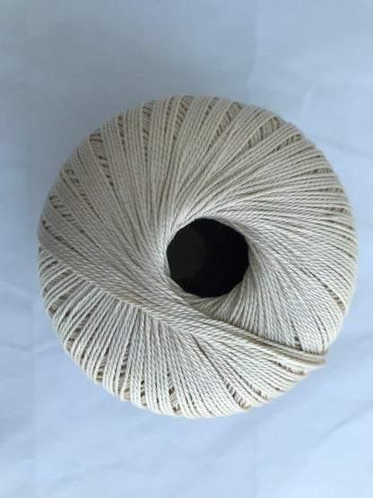 Spool of beige thread on a white background