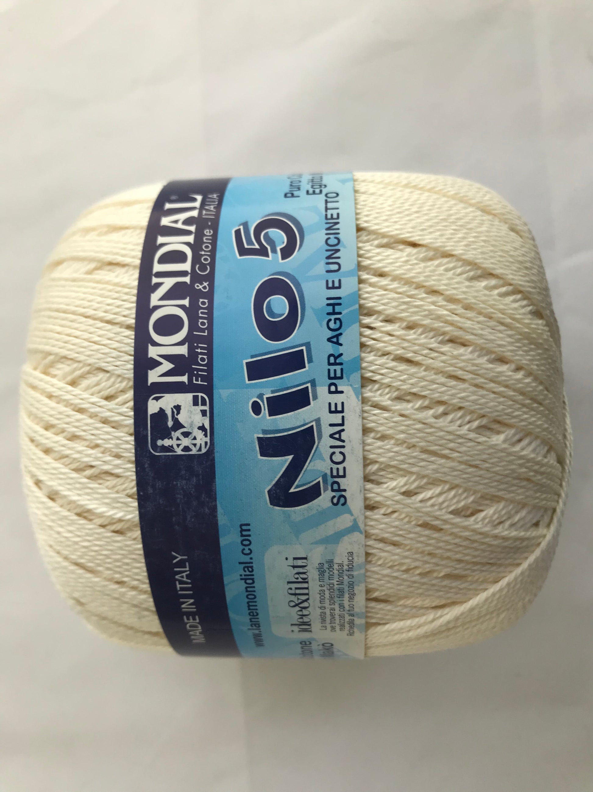 Ball of yarn with Mondial Nilo 5 label on a light gray background